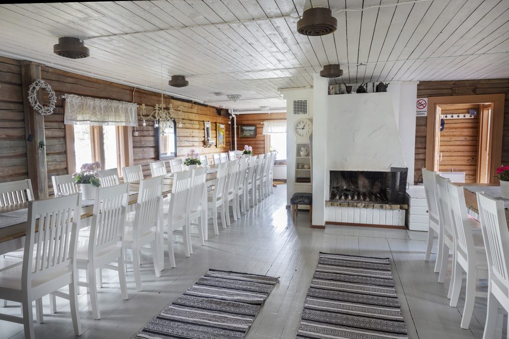 Höytiäisen Helmen sali, jossa pitkät ruokapöydät ja avotakka.