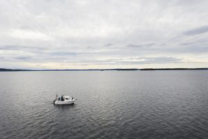 Uisteluvene ylhäältä viistosta kuvattuna pilvisellä järven selällä.